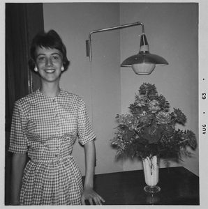 Author Judy Ashley in August 1963, standing next to a bouquet of flowers.