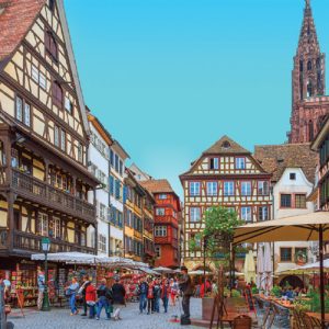 City center scene, with traditional buildings and pedestrians walking in Strasbourg, France.