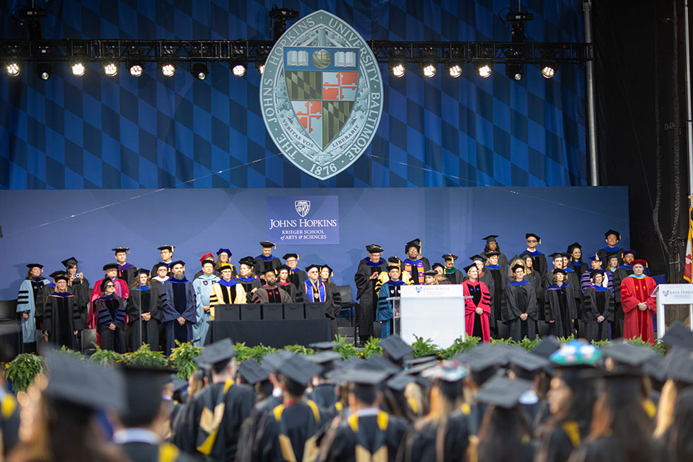 Stage view of the faculty and keynote speaker Kevin Young at the 2023 KSAS graduation ceremony.