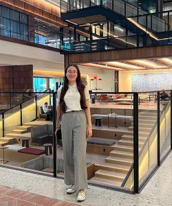 Kaylee Law standing in front of interior staircase inside the Johns Hopkins University Bloomberg Center.