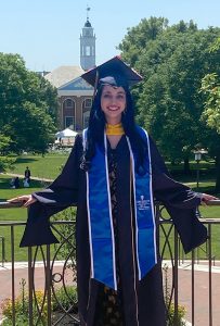 Mifrah Hayath on Homewood campus in Baltimore, wearing a cap and gown.