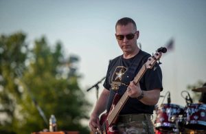 Dustin Whitcomb playing bass guitar.