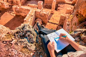 Archeological dig site - person drawing a diagram of the site.