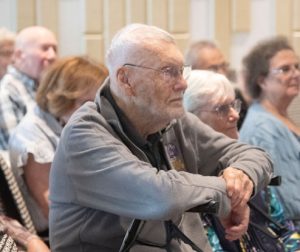 Member Bill Brustad and others watch presentations at the Osher 40th anniversary event.
