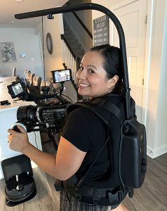 Araceli Frias-Ohane on set, wearing a camera rig.