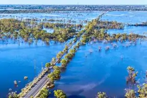 Aerial photograph of a landmass covered in water, and a road disappearing into the water.